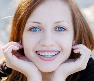 A young woman with braces smiling.